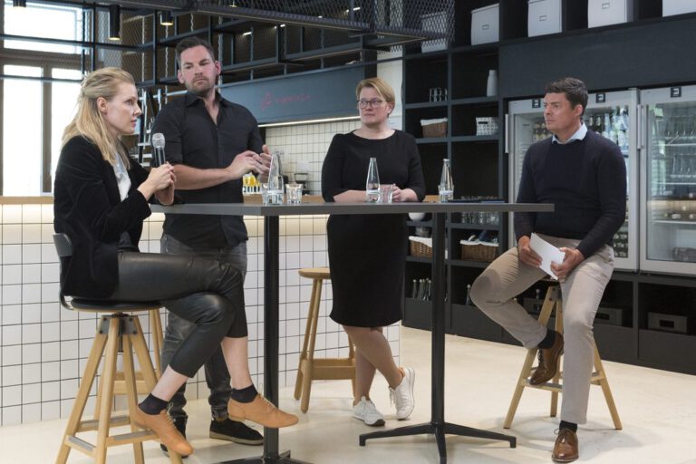 Sandra Cameron speaking on a panel with three participants.
